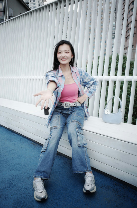 Young woman in casual clothes sits on a bench.